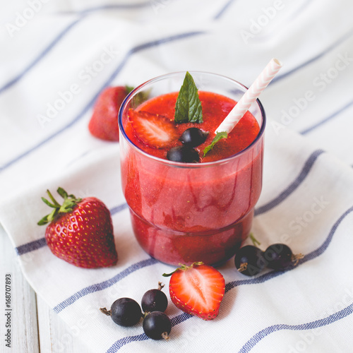 Smoothies of black currant and strawberries with yogurt on a white wooden table. photo