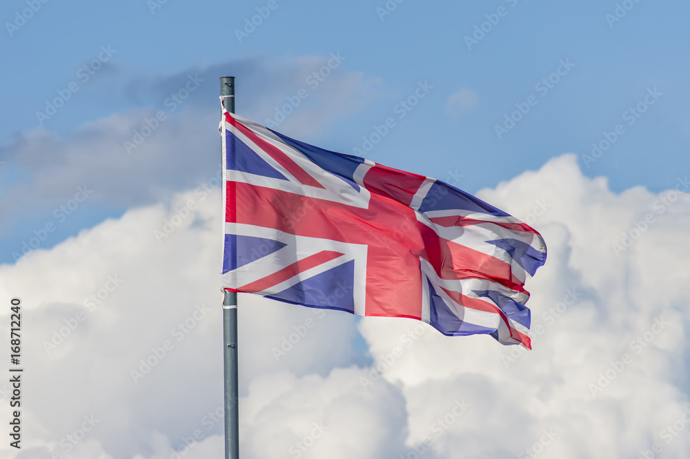 The National flag of United Kingdom flay over the blue sky