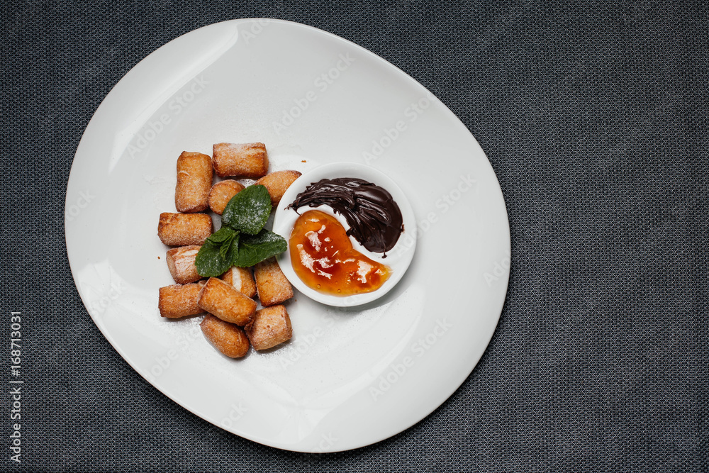 Sweet donuts with chocolate and apricot sauces Sweet donuts with chocolate and apricot sauces