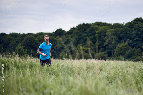 Fitter muskulöser Mann trainiert und läuft an einem Feldweg