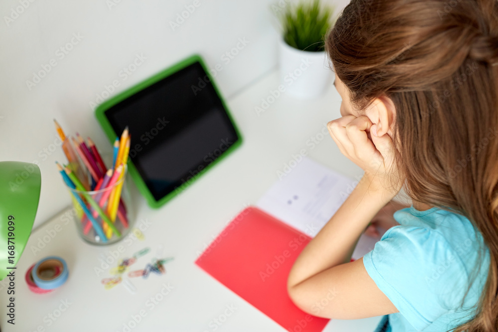 girl with tablet pc writing to notebook at home girl with tablet pc writing to notebook at home