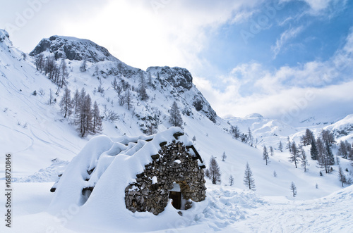 Mountain hut made of stones - shelter for mountaneers from the snow storm in winter, mountain Vogel, slovenian Alps, Slovenia