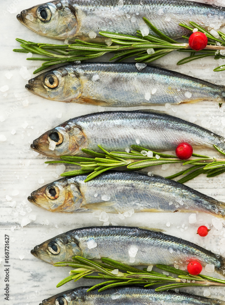 Fresh raw fish Baltic herring on a table with fresh herbs and cowberry. Fresh raw fish Baltic herring on a table with fresh herbs and cowberry.