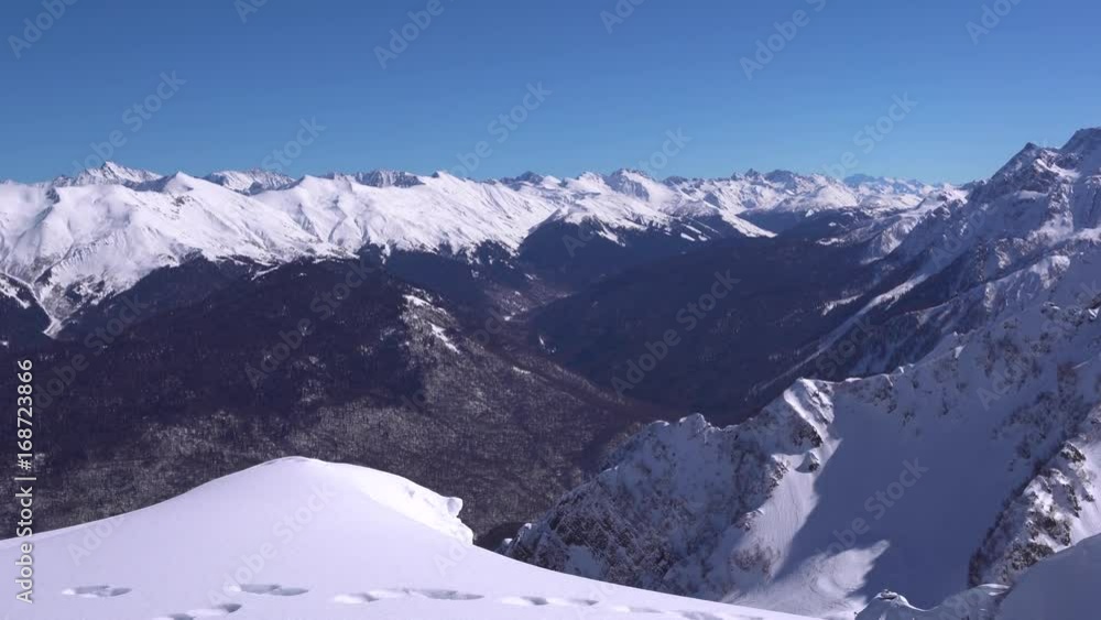White peaks of the Caucasus at sunny day. Panning shot of ridges in Krasnaya Polyana, Russia White peaks of the Caucasus at sunny day. Panning shot of ridges in Krasnaya Polyana, Russia
