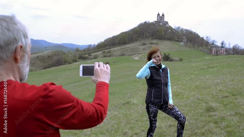 Active senior runners in nature taking photo with smart phone. Active senior runners in nature taking photo with smart phone.