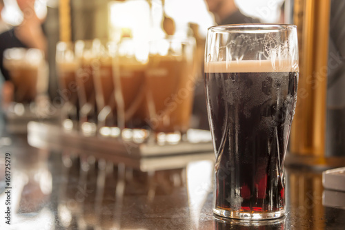 Close up of a glass of stout beer in a bar, irish pub, Saint Patrick day celebration photo