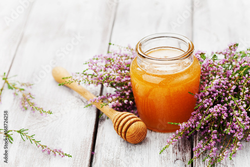 Quadro su tela Fresh honey in pot or jar and flowers heather on wooden vintage table