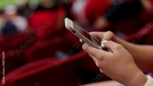 Closeup Of Bored Teen Playing On Smartphone At A Professional Sporting Event In A Stadium
