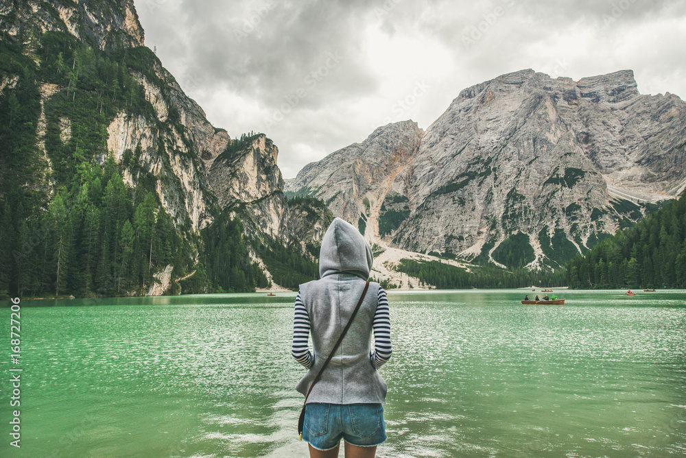 Φωτογραφία Young woman traveller in hoodie standing and looking at Lago di Braies or Pragser Wildsee in Fanes-Sennes-Braies Nature Park