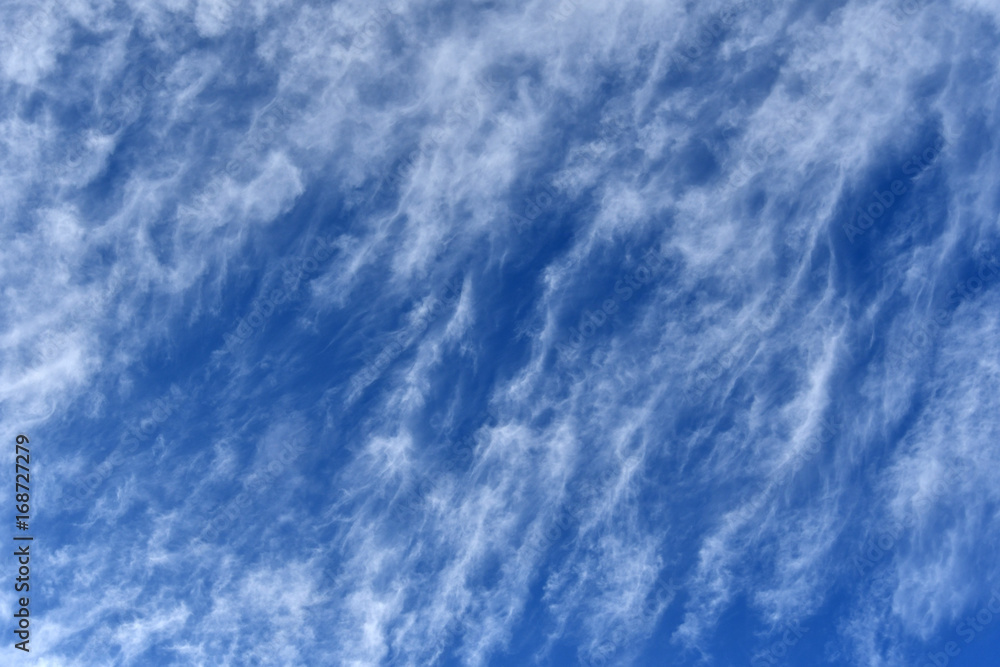 Wispy white cirrus clouds on dark blue sky background Wispy white cirrus clouds on dark blue sky background