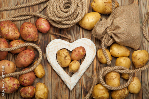 Potatoes and heart on a wooden background