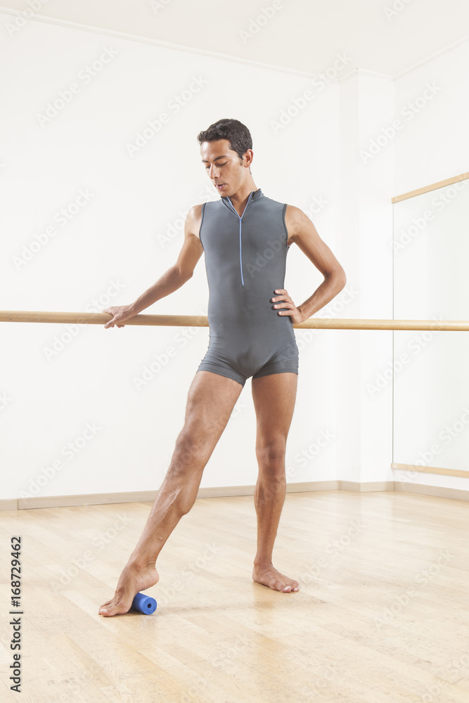 Obraz premium professional ballet dancer stretching and warming up using foam roller