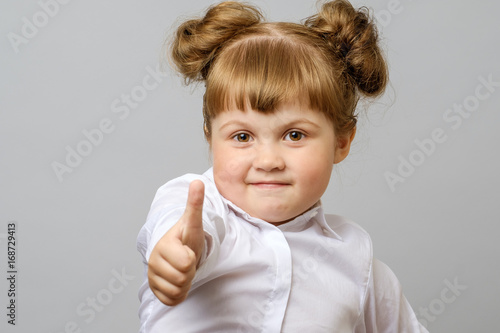 Portrait of cute girl showing thumbs up sign
