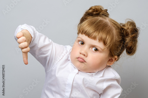 Foto Unhappy little girl showing thumb down