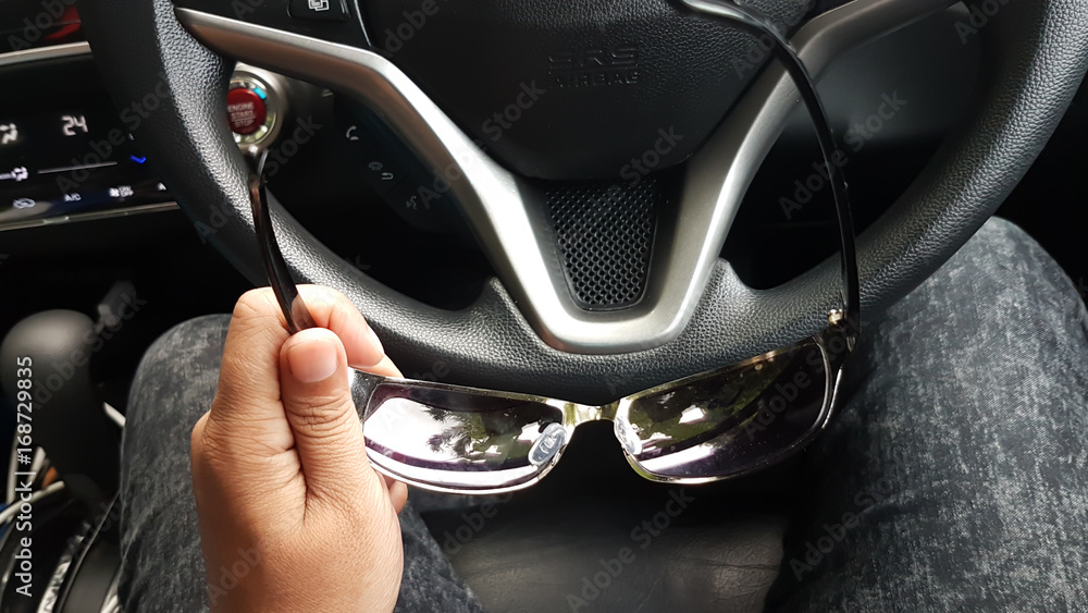 Sun glasses in man hand before drive the car Sun glasses in man hand before drive the car