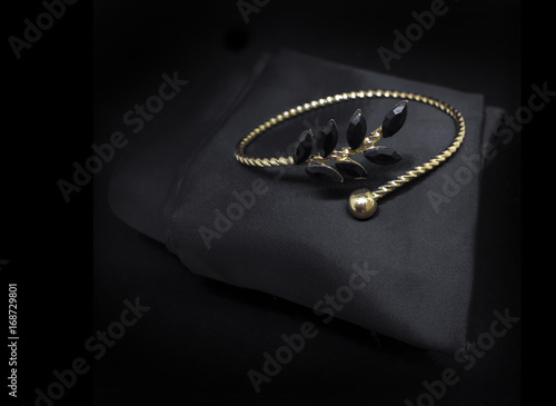 Fotografia Jewellery black diamonds gold bracelet isolated on black cloth background