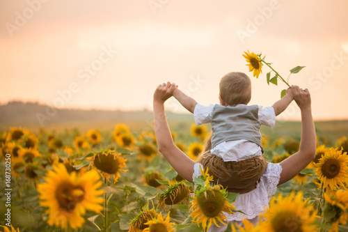 Mother with baby son in sunflower field