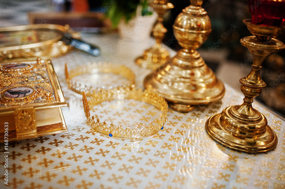 Close-up photo of crowns laying on the table next to the candlesticks and bible in the church. Close-up photo of crowns laying on the table next to the candlesticks and bible in the church.