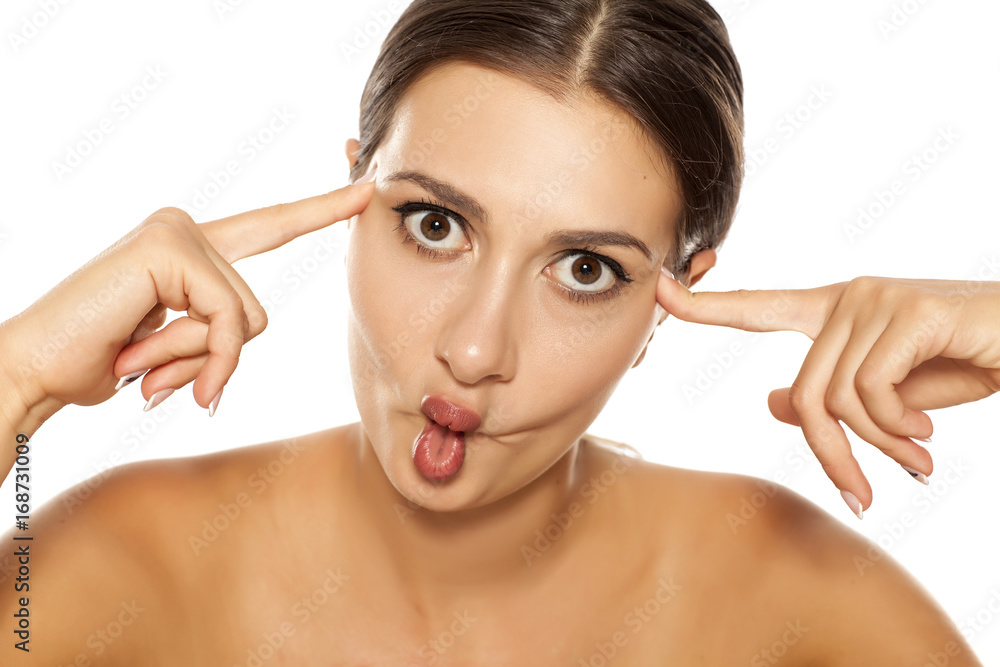 A pretty young woman make a fish face on a white background Stock