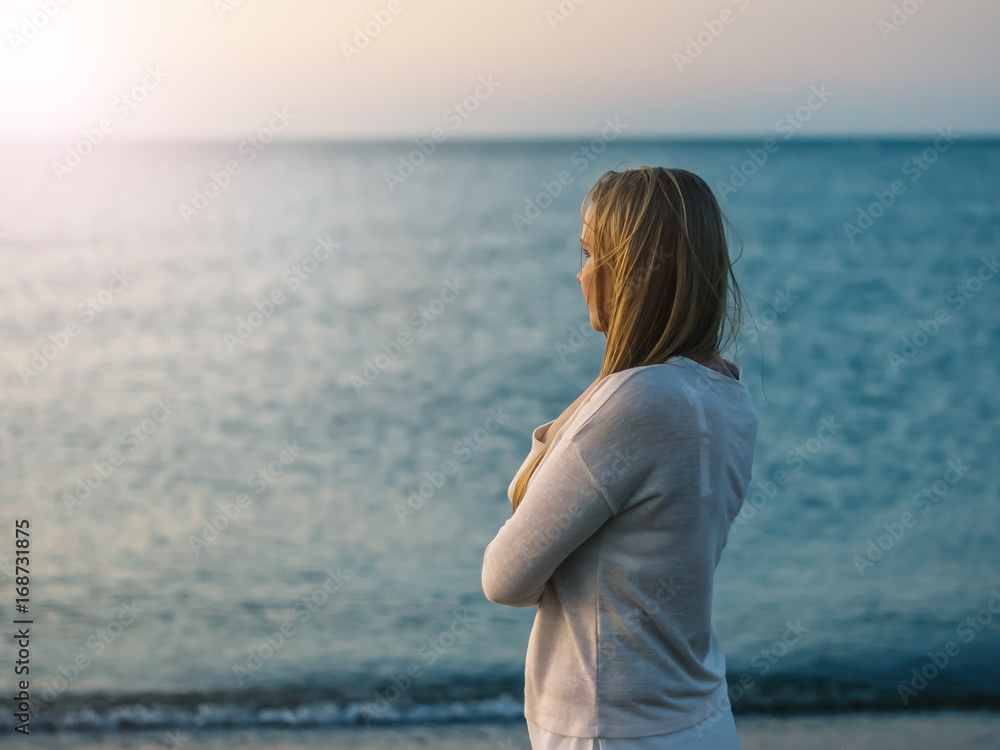 Woman with folded on his breast, the hands looks at the setting sun. Woman with folded on his breast, the hands looks at the setting sun.