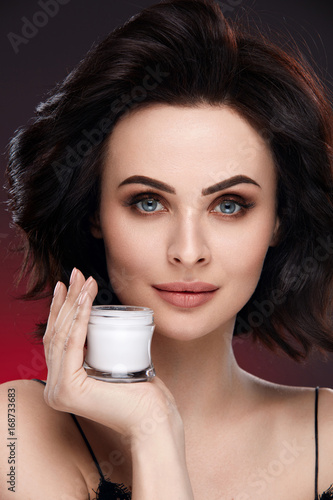 Face Cream. Beautiful Female Model Holding Cream