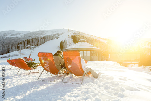 CHOPOK, SLOVAKIA - JANUARY 12, 2017: Skiers and snowboarders taking a rest in chairs near apres ski bar at Chopok downhill, January 12, 2016 in Jasna - Slovakia