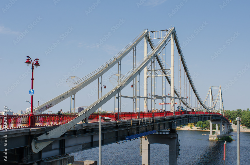 Obraz premium Pedestrian Park Bridge to the Truhaniv Island in Kiev, Ukraine, on a sunny summer day
