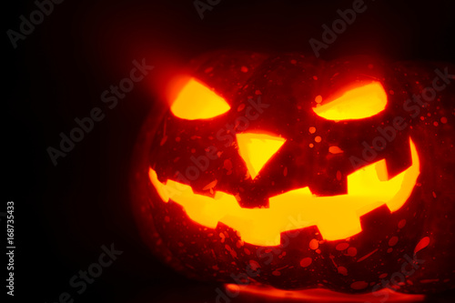 Composed glowing carved pumpkin lying on surface in mist