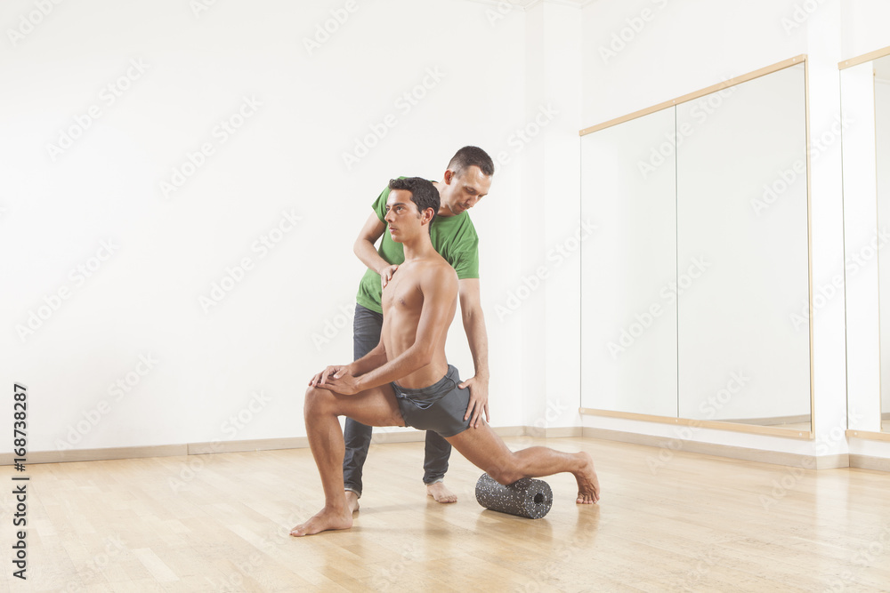 pilates instructor teaching a ballet dancer using foam roller pilates instructor teaching a ballet dancer using foam roller