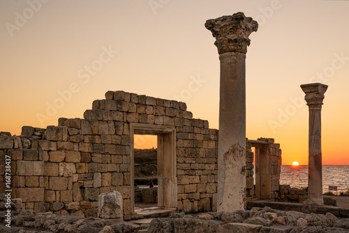 Sun setting by ancient basilica columns of Creek colony Chersonesos in Sevastopol, Crimea photo