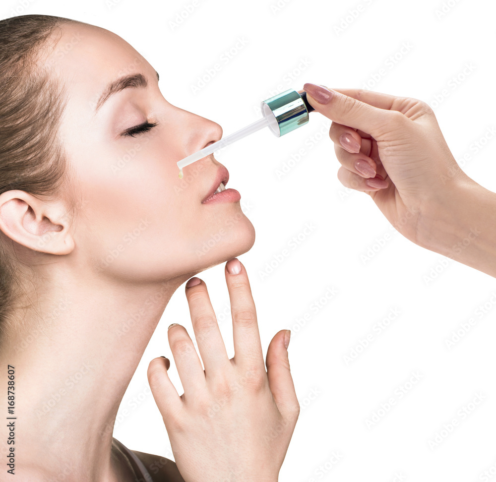 Cosmetic oil applying on face of young woman. Cosmetic oil applying on face of young woman.