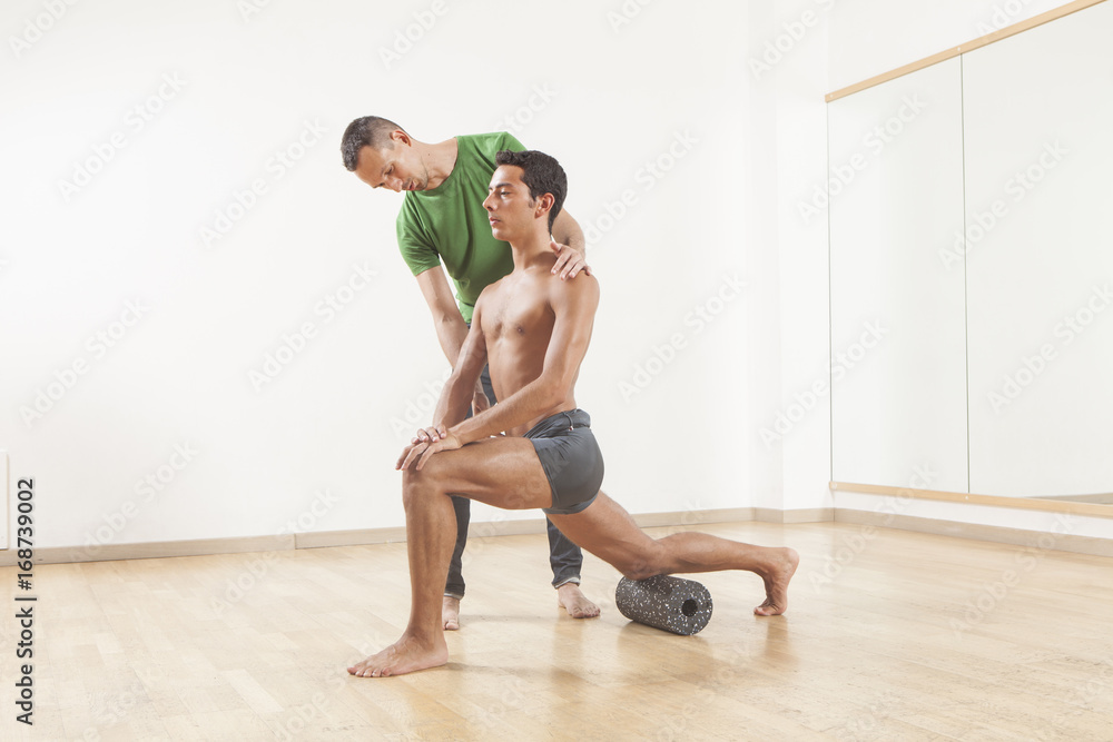 pilates instructor teaching a ballet dancer using foam roller