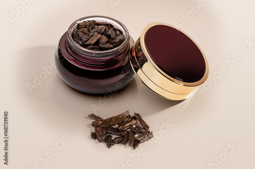 Incense of Traditional Arabian Fragrance Oudh Bakhoor in a maroon glass jar on light background photo