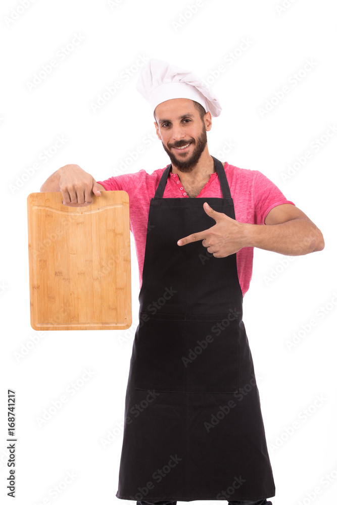 Happy beard chef smiling and holding a wooden cutting board, guy wearing a black chef uniform and chef hat, isolated on white background Happy beard chef smiling and holding a wooden cutting board, guy wearing a black chef uniform and chef hat, isolated on white background