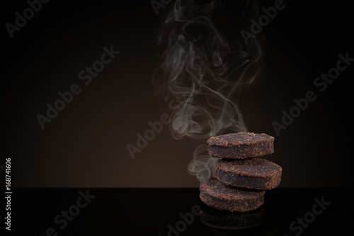 Incense of Traditional Arabian Fragrance Oudh Bakhoor smoking on black background