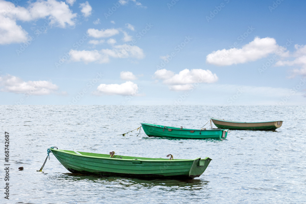 Three wooden boats at sea
