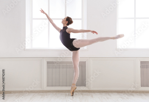 Beautiful ballerina stands in ballet arabesque