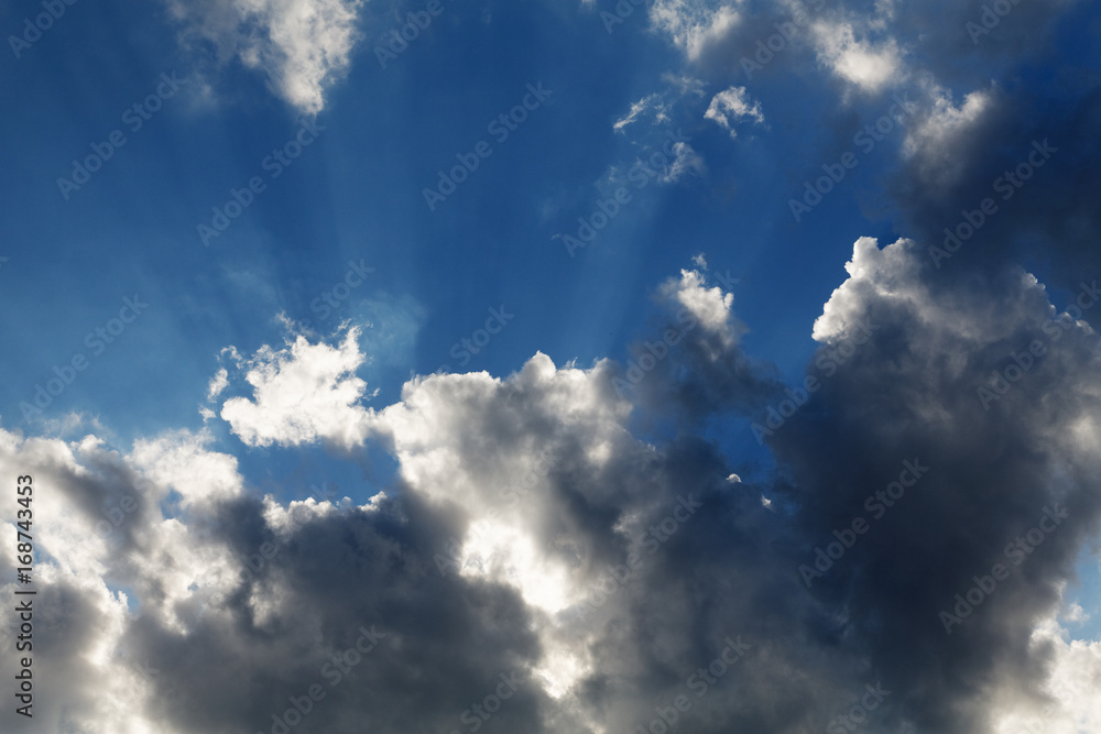 Clouds with rays of sun on a background of blue sky Clouds with rays of sun on a background of blue sky