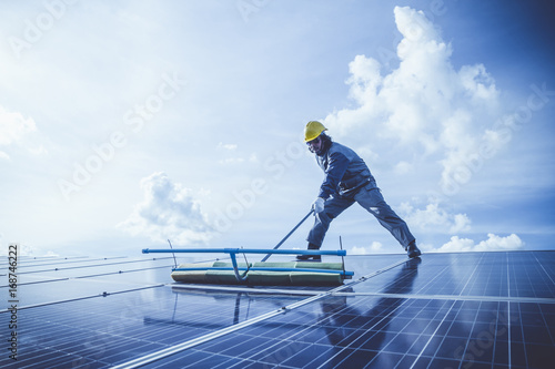labor working on cleaning solar panel with water clean at solar power plant
