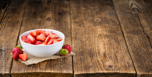 Wooden table with Strawberries (Chopped), selective focus