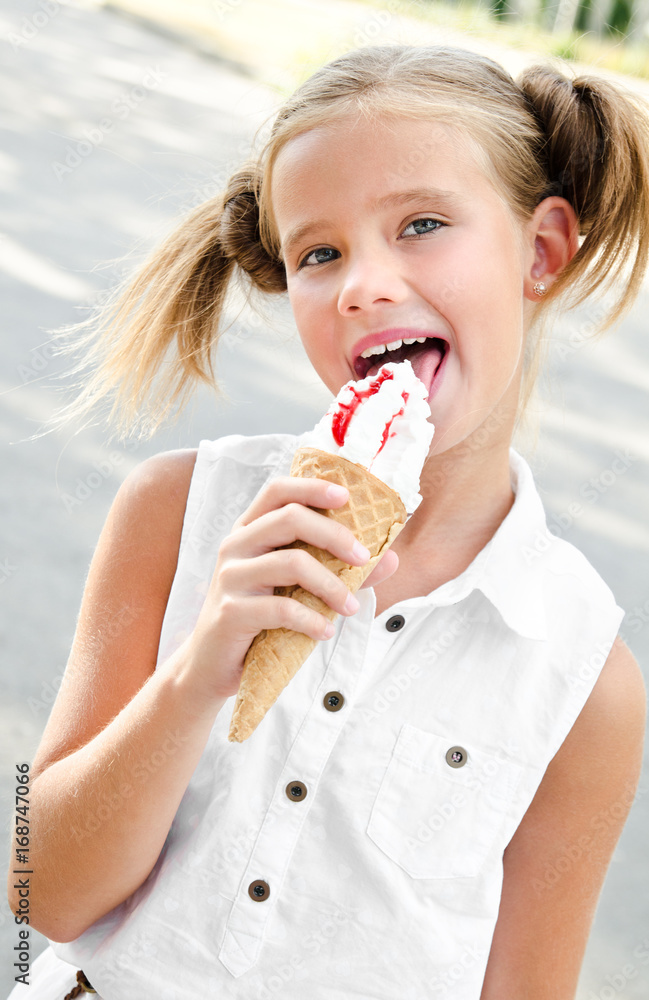 Cute smiling little girl eating an ice cream Cute smiling little girl eating an ice cream