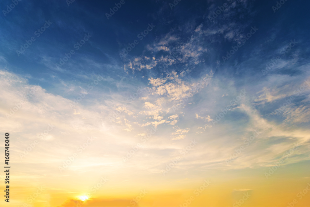 Naklejka premium Sky background at sunset,Sky blue and orange light of the sun through the clouds in the sky