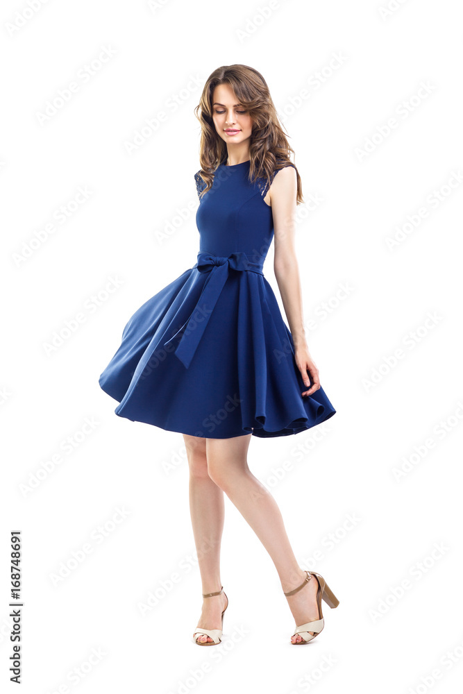 Happy beautiful woman in blue dress posing in studio