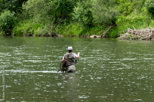 Fly fisherman flyfishing in river 