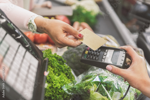 Buyer giving plastic card to cashier