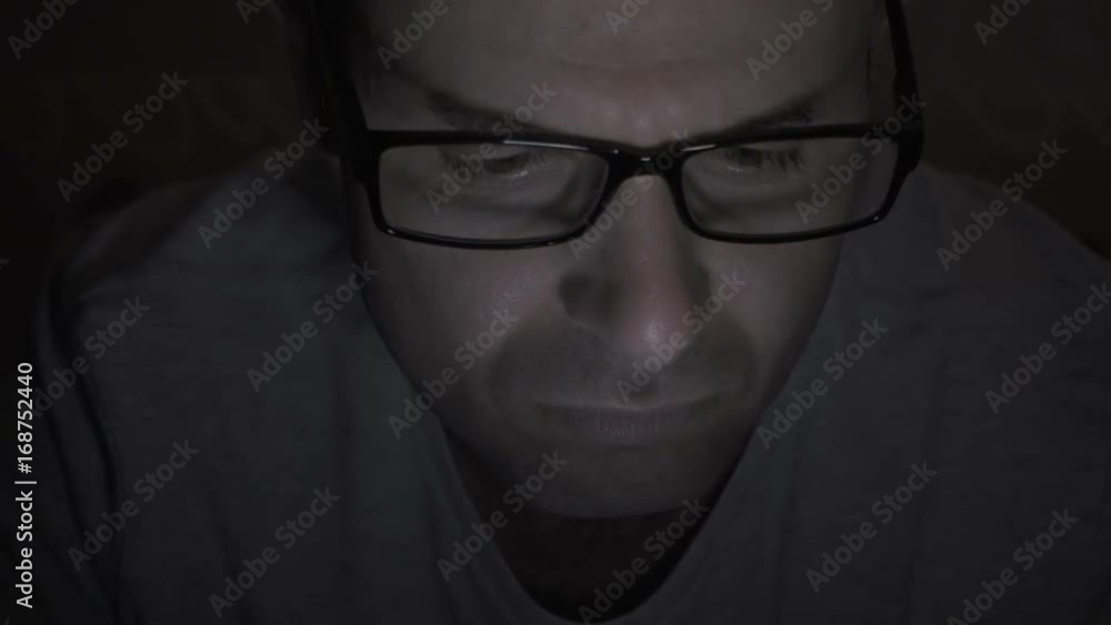 Close up of man with glasses using smartphone. Young man with tablet computer. A man at night on social networks using a smartphone. Close up of man with glasses using smartphone. Young man with tablet computer. A man at night on social networks using a smartphone.