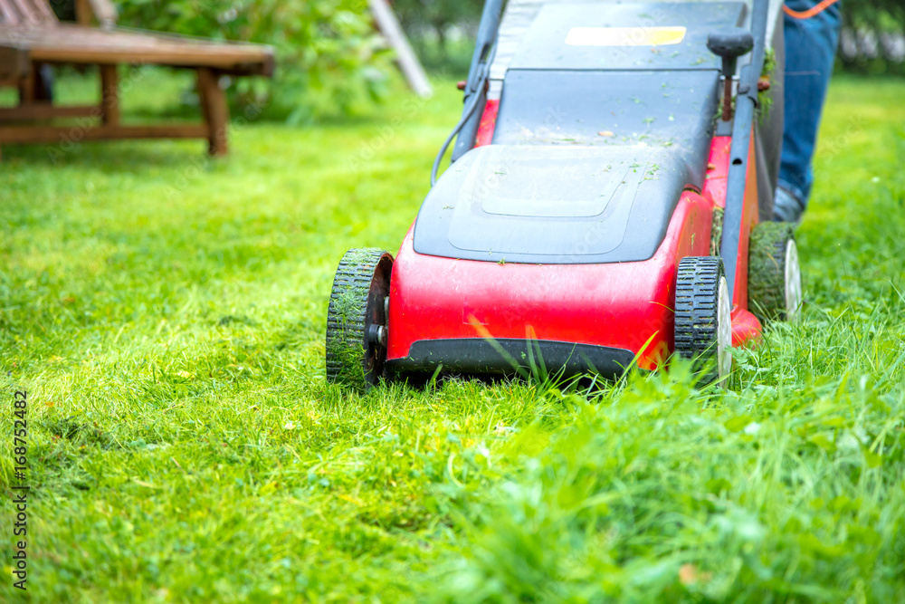 Mann Mäht rasen im eigenem Garten Mann Mäht rasen im eigenem Garten