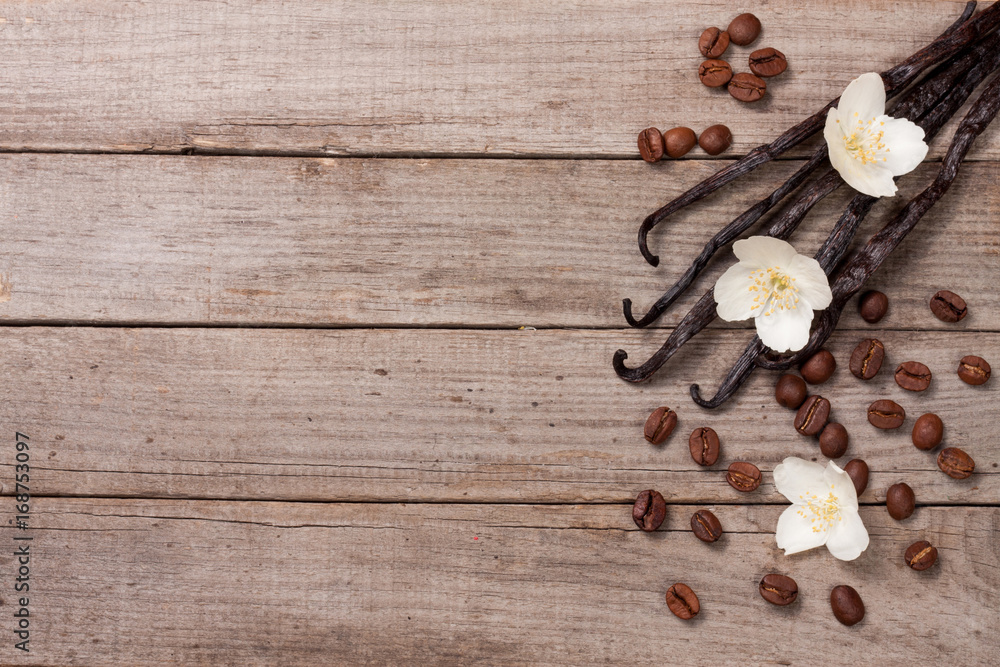 Vanilla sticks with coffee beans avd flower on a old wooden background with copy space for your text. Top view Vanilla sticks with coffee beans avd flower on a old wooden background with copy space for your text. Top view