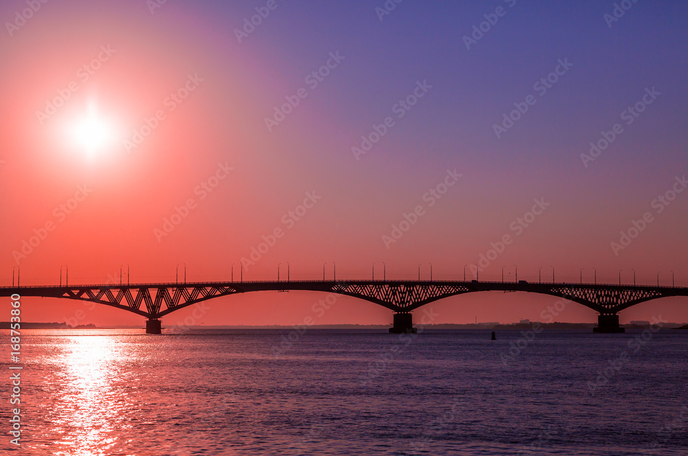 Sunrise over a road bridge across the Volga river between the cities of Saratov and Engels, Russia. Sunrise over a road bridge across the Volga river between the cities of Saratov and Engels, Russia.