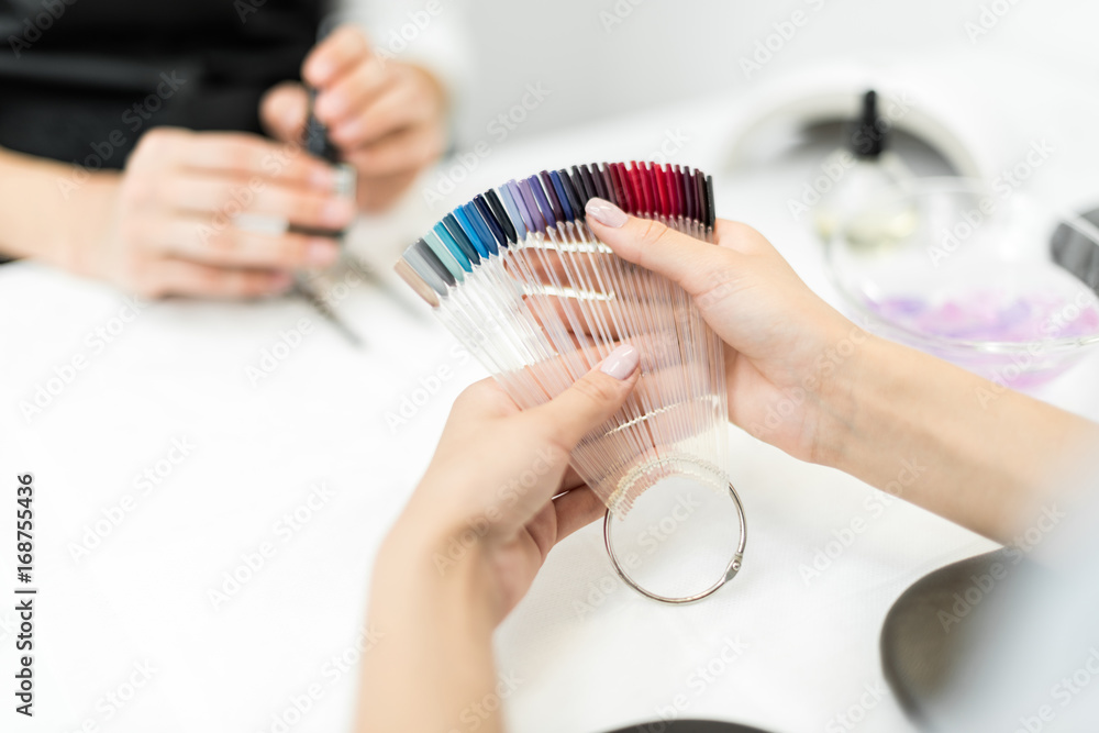 woman choosing nail polish color